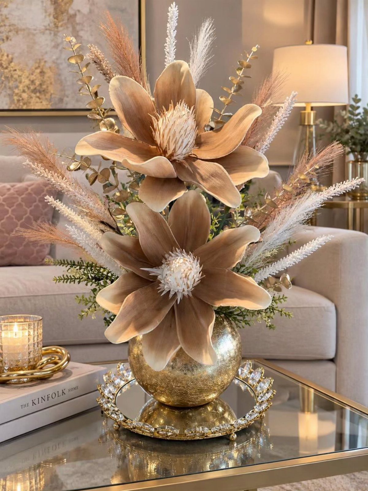 Gold flower centerpiece in a spherical vase on a mirrored crystal tray.