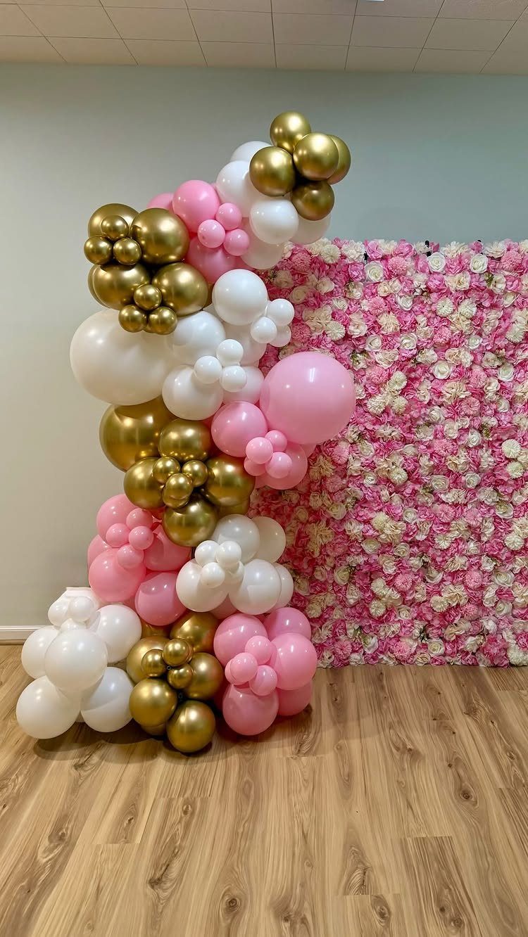 Pink and white flower wall backdrop with a gold, pink, and white balloon arch.