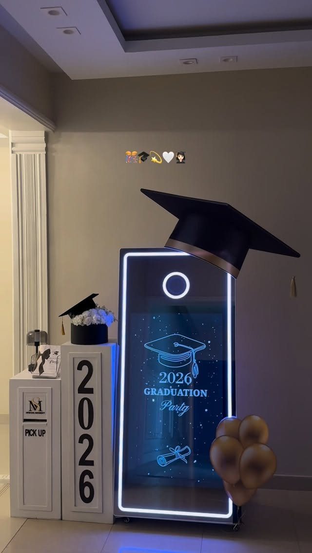 Digital photo booth mirror decorated with a graduation cap and gold balloons.