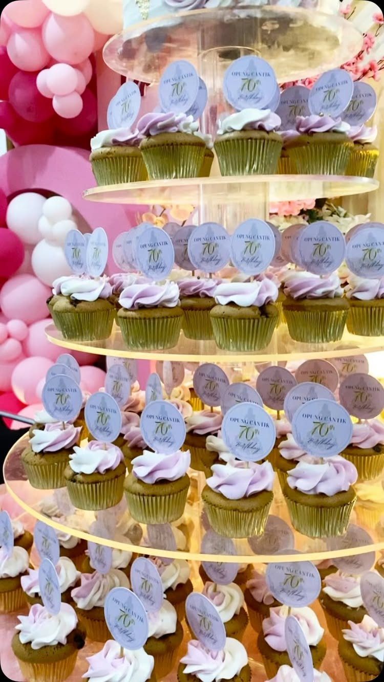 Cupcakes with purple and white frosting arranged on a tiered clear acrylic stand.