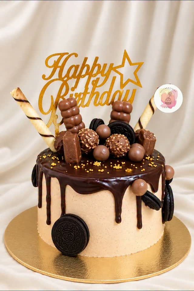 Chocolate birthday cake with chocolate drip, cookies, and a gold Happy Birthday topper.