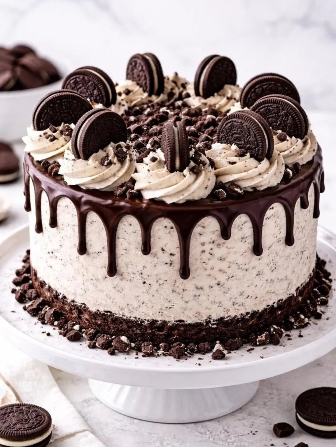 Oreo cake with chocolate drip and sandwich cookies on a white stand