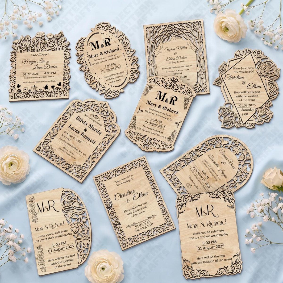 Laser-cut wooden wedding invitations in various shapes arranged on light blue fabric with flowers.