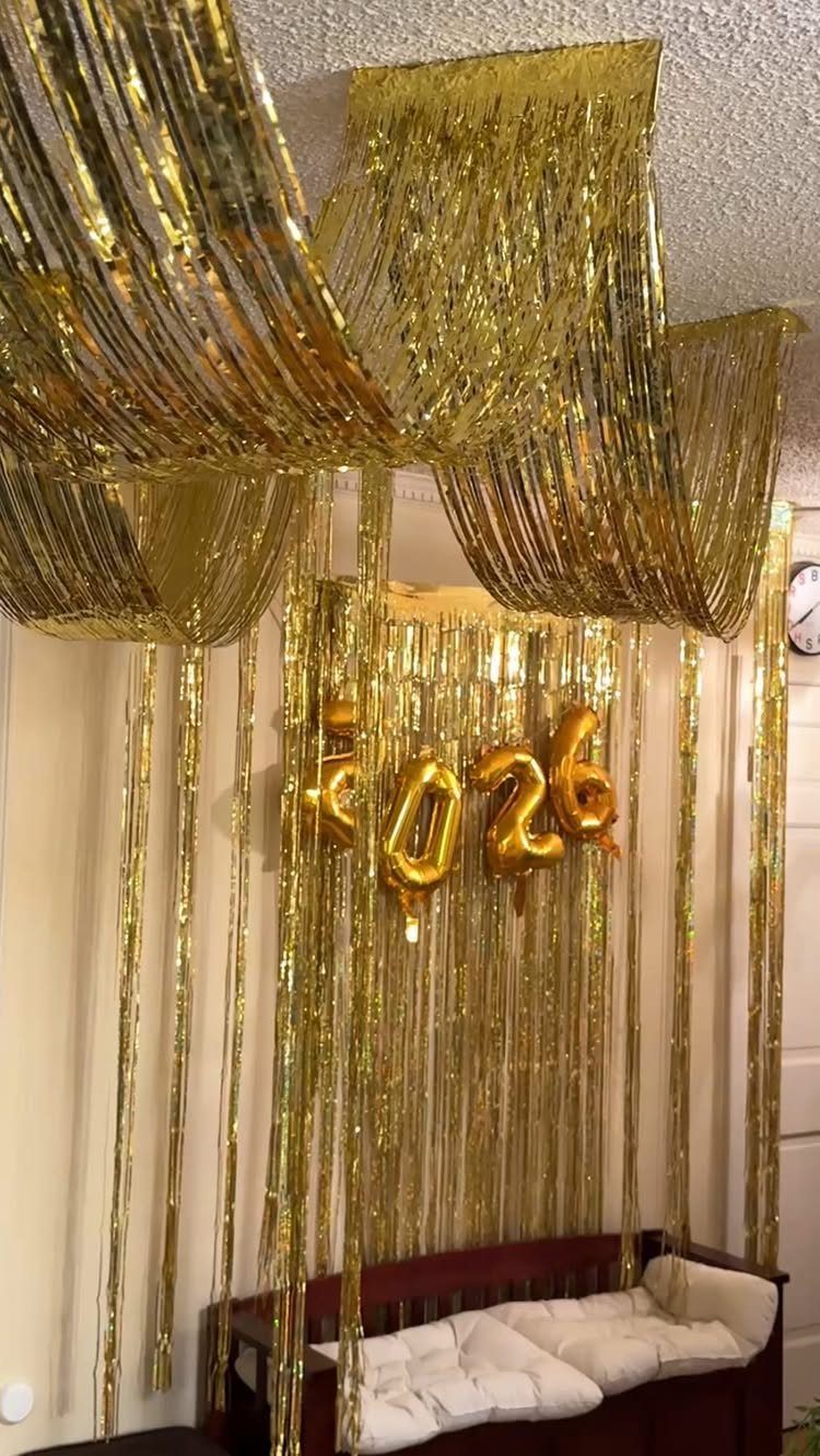 Gold metallic foil curtains draped from ceiling and wall with 2026 balloons