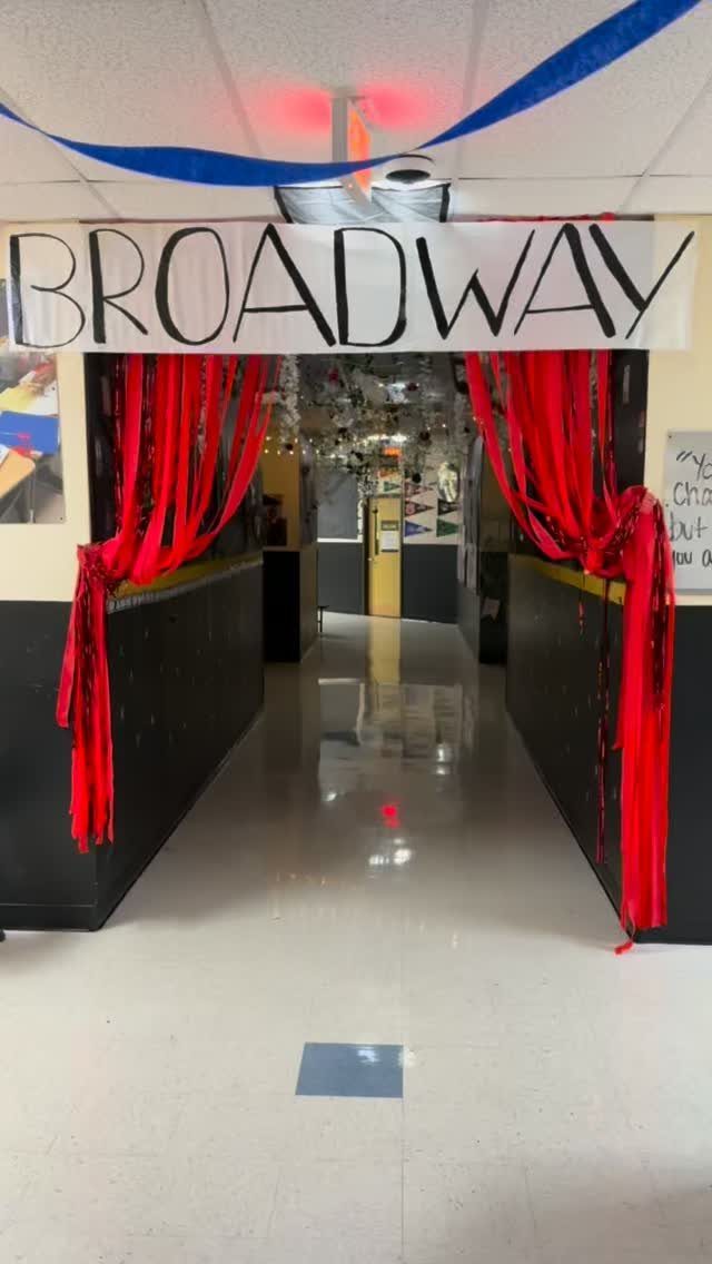 Broadway themed hallway entrance with red curtains and a hand-written banner.