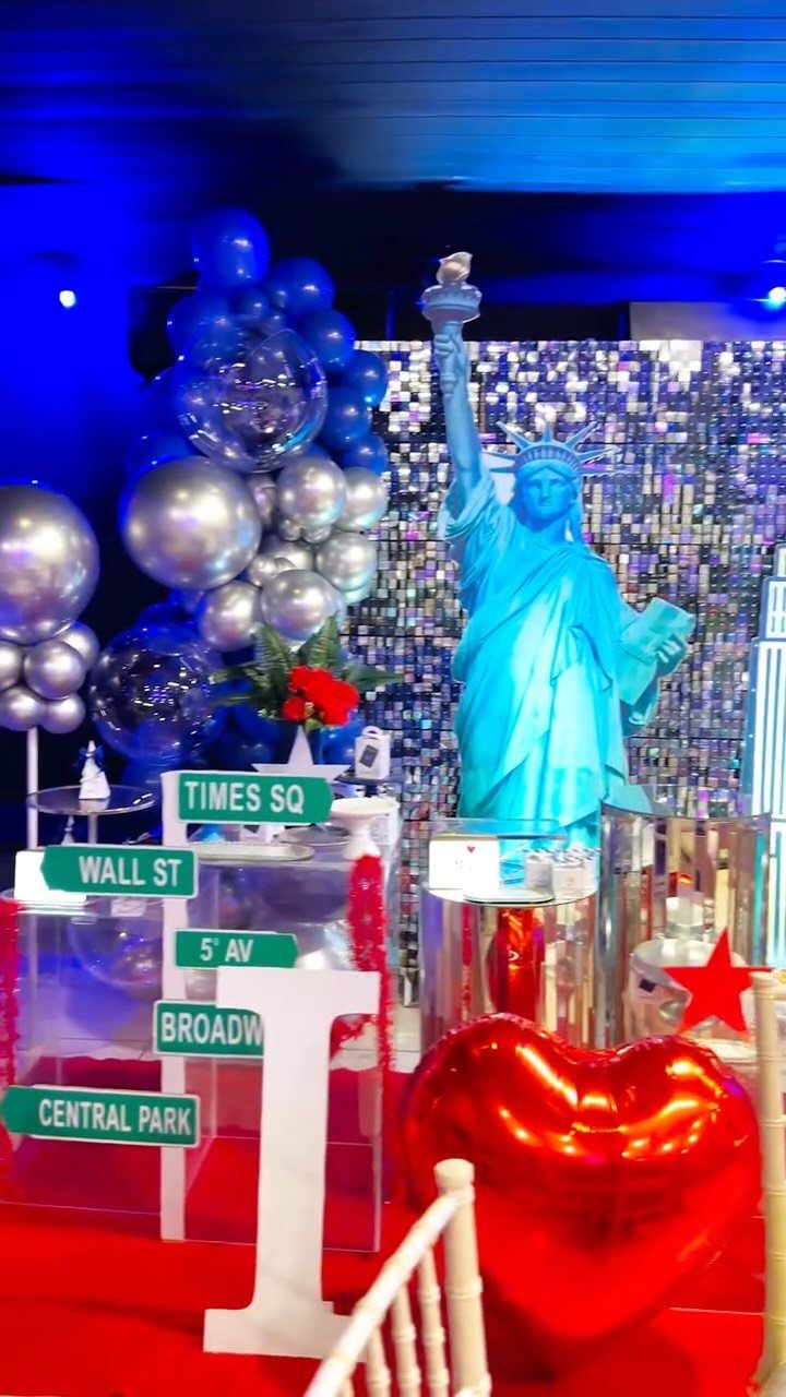 Statue of Liberty figure with New York street signs and blue silver balloons