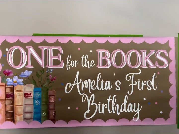 Brown birthday banner with pink borders, book illustrations, and 'One for the Books' text.