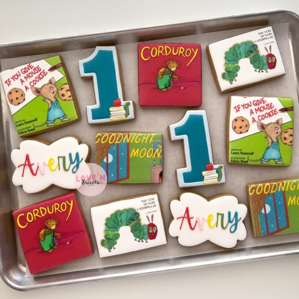 Decorated sugar cookies featuring children's book covers and the name Avery on a tray.