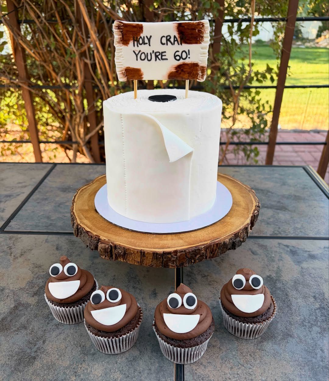 Toilet paper roll cake and poop emoji cupcakes for a 60th birthday party.
