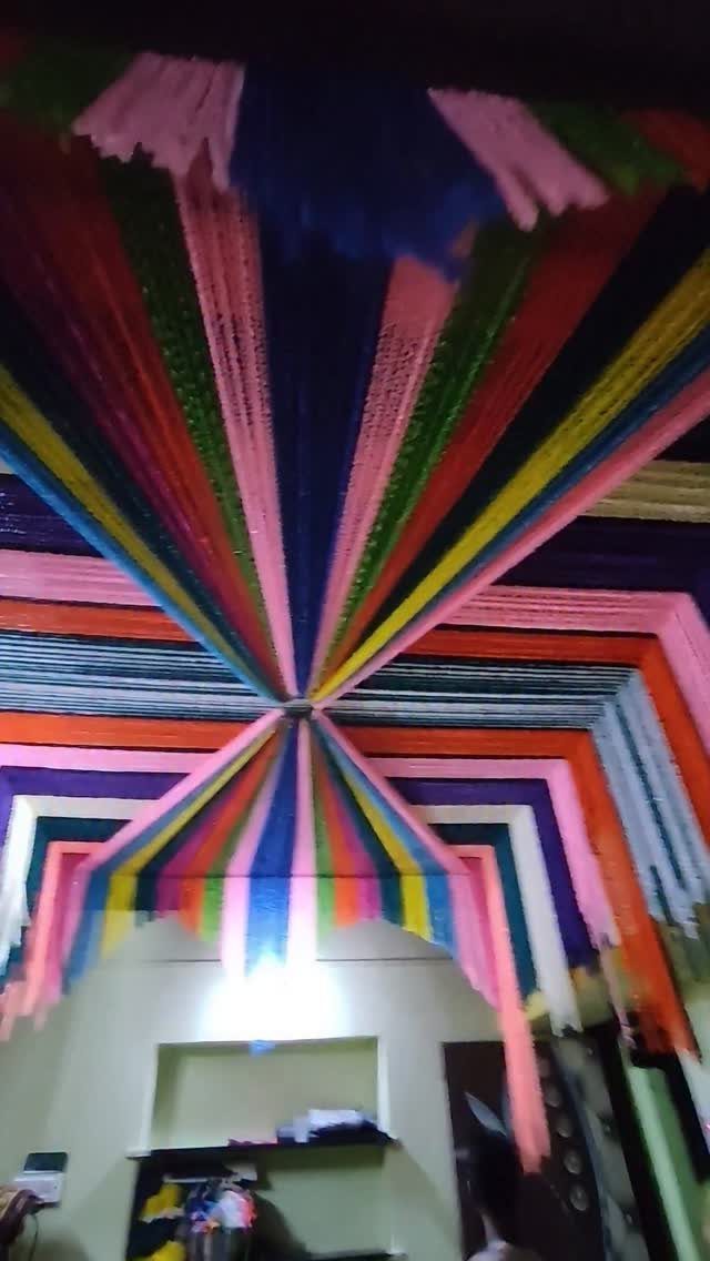 Colorful fabric streamers radiating from a ceiling center to decorate a room.