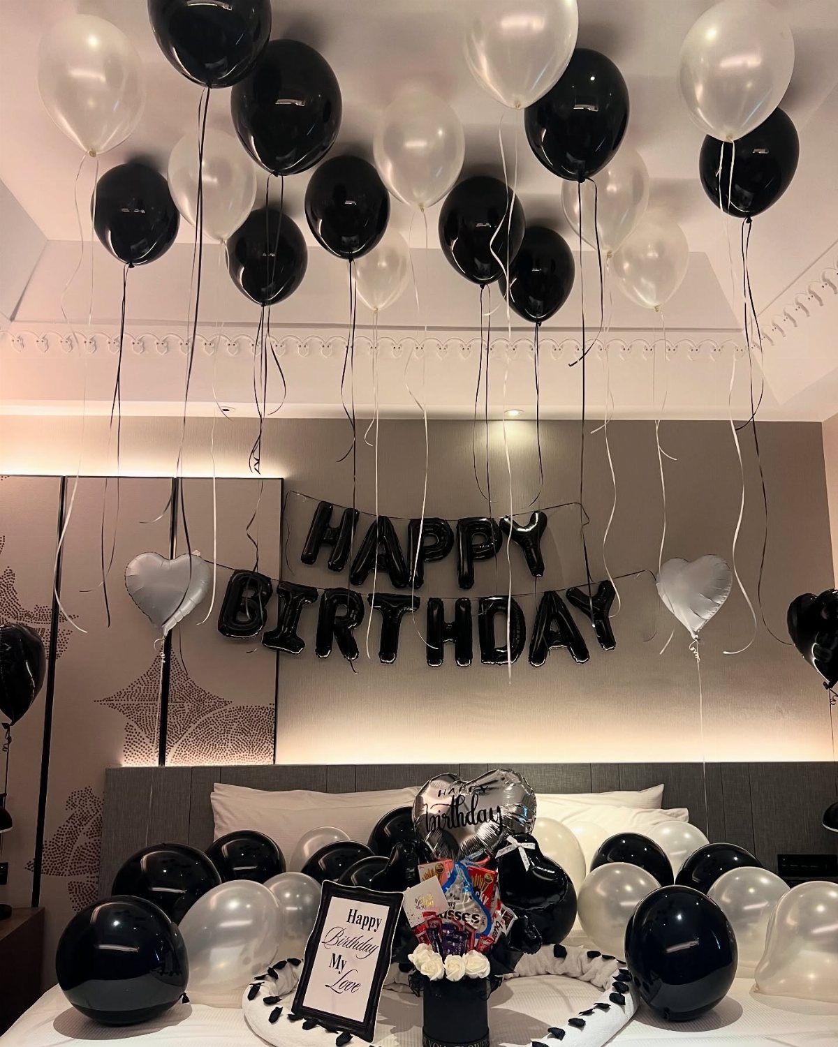 Bedroom decorated with black and white balloons and foil Happy Birthday letters