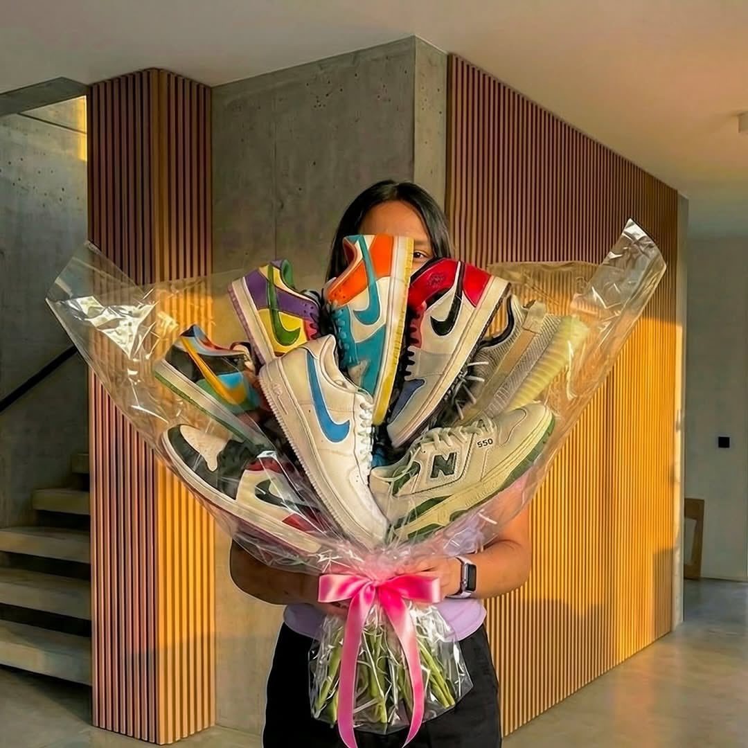 Bouquet of colorful sneakers wrapped in clear cellophane with a pink ribbon bow.