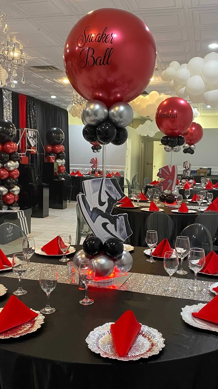 Banquet table with red and silver balloons and sneaker cutouts for a party.