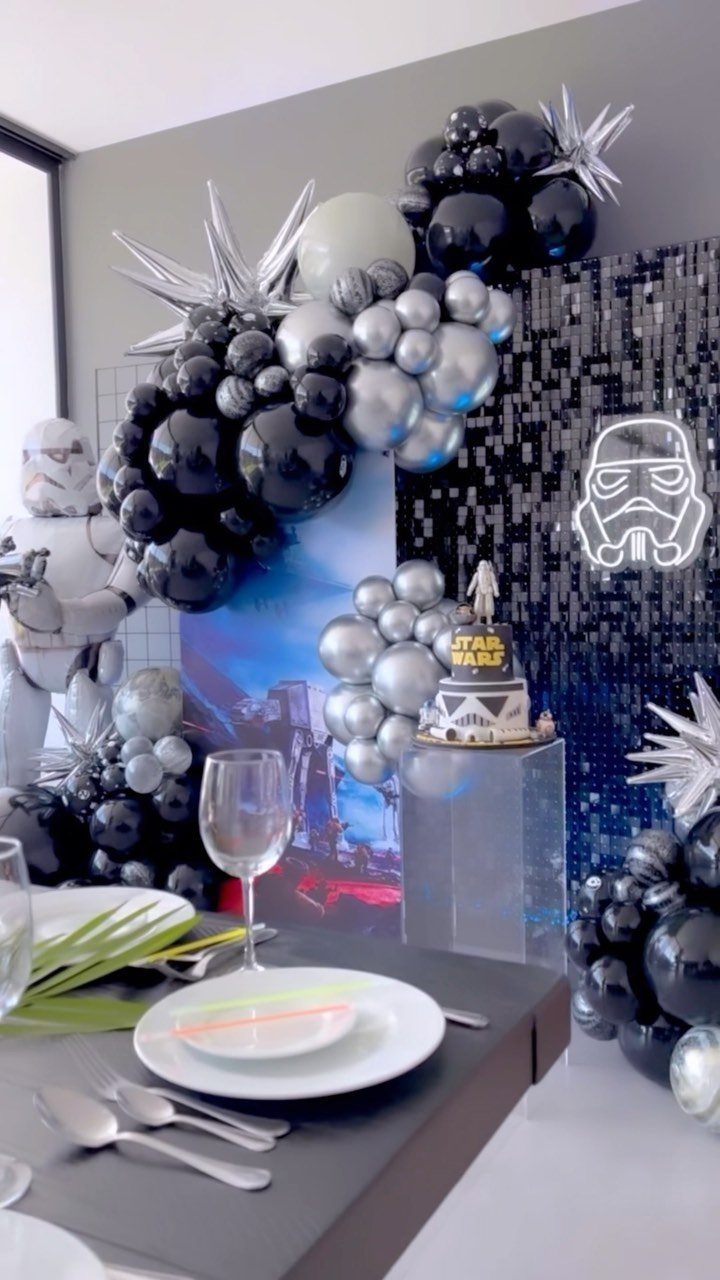 Star Wars party decorations with black and silver balloons and a Stormtrooper costume.