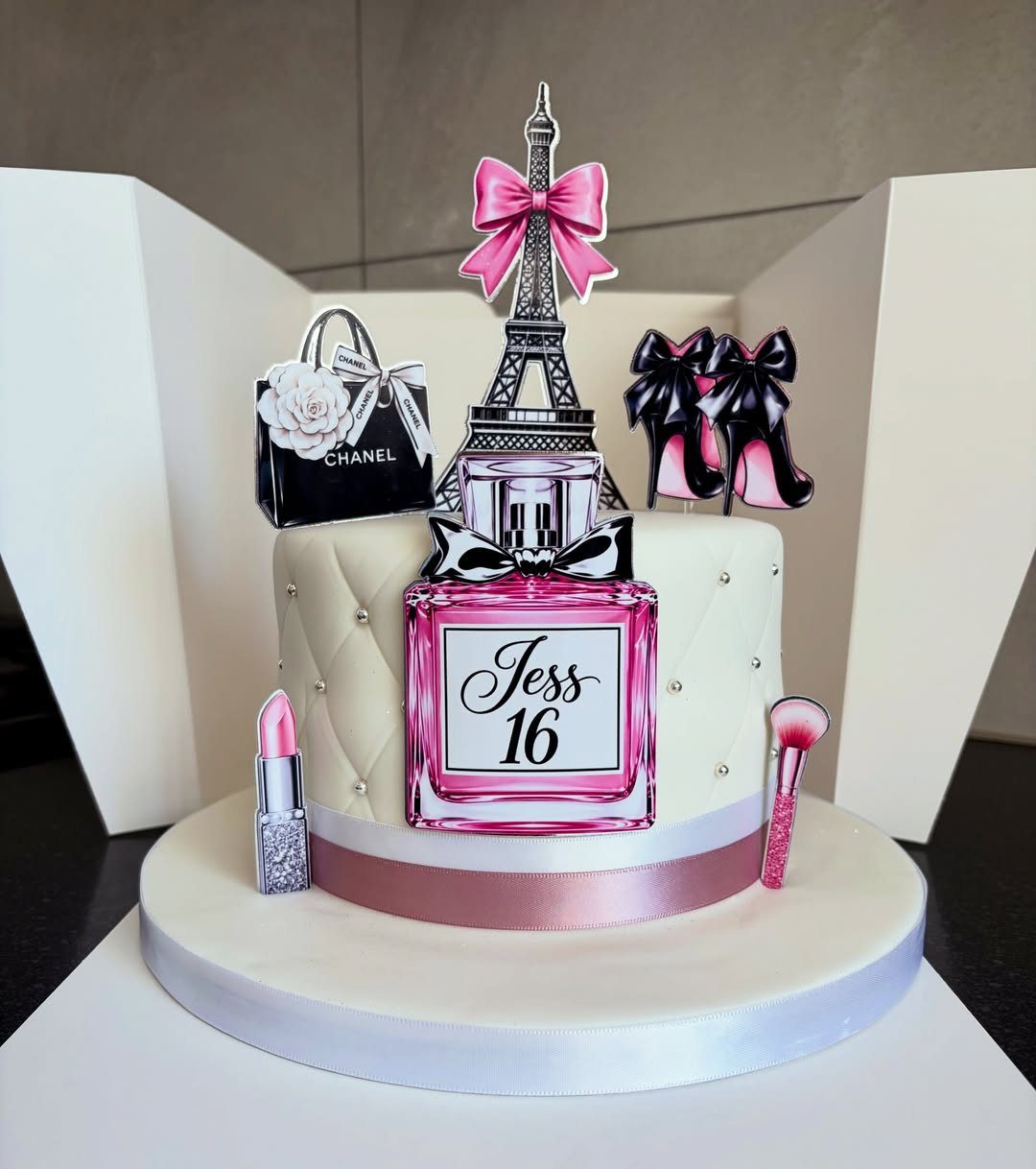 White quilted birthday cake with Chanel handbag, Eiffel Tower, and makeup toppers.
