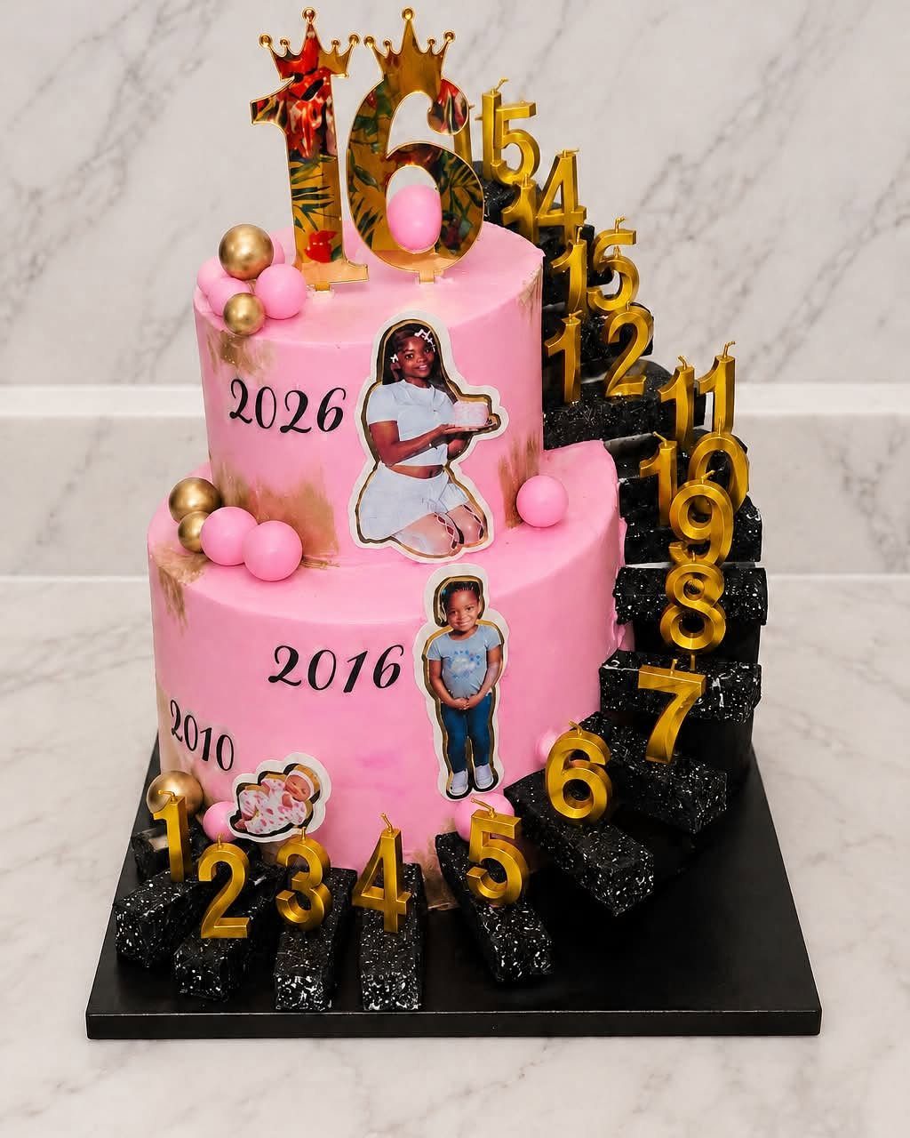 Two-tier pink birthday cake with a black glittery staircase and gold number decorations.