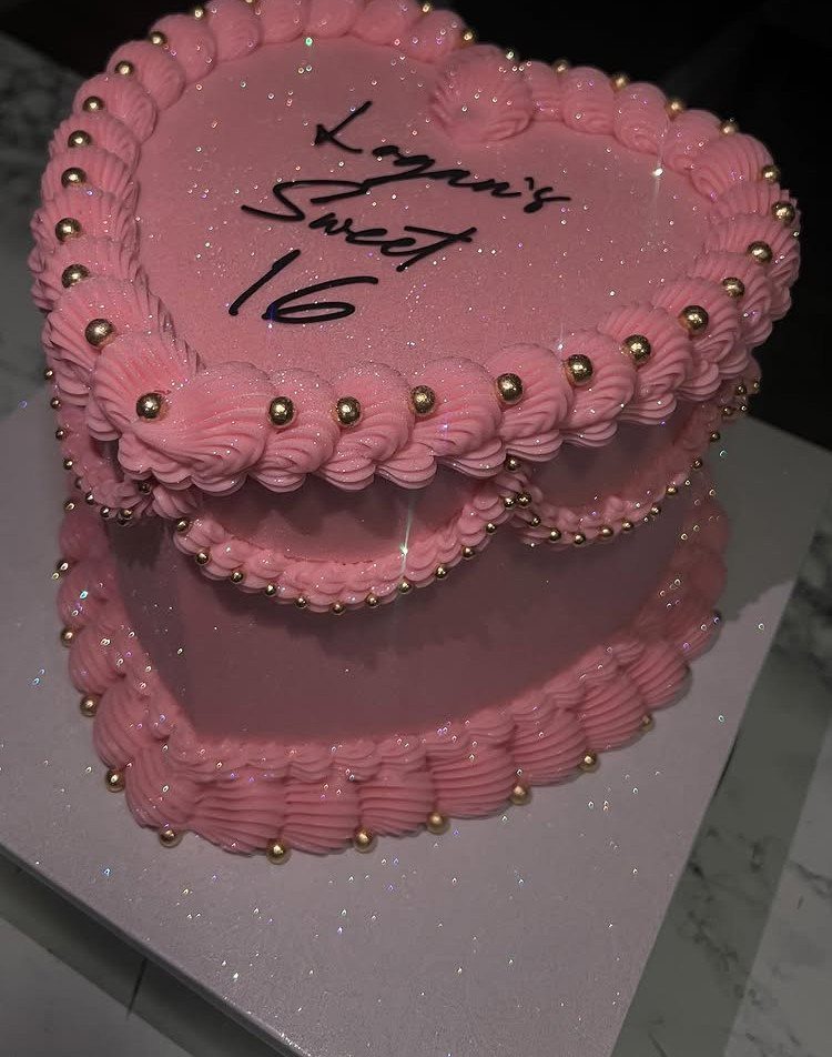 Heart-shaped pink two-tier cake with gold pearls and Sweet 16 writing