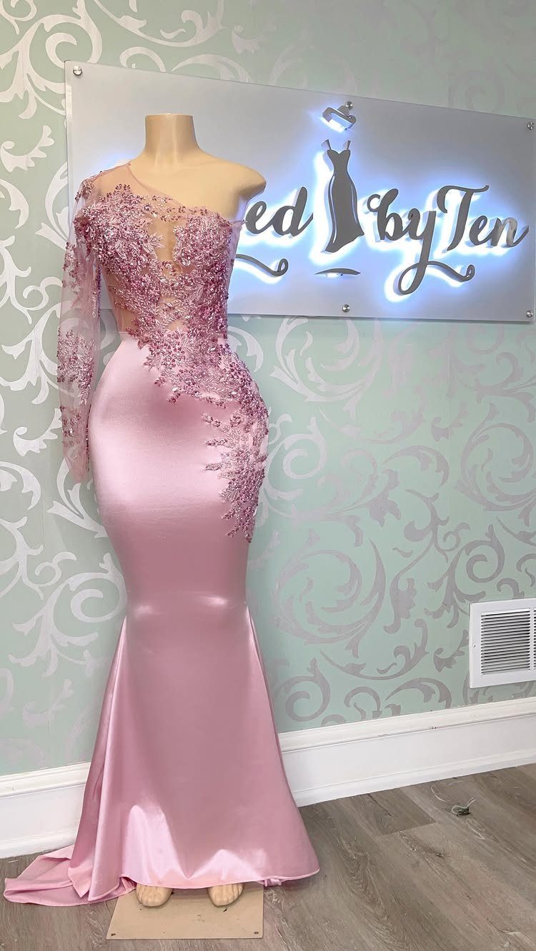 Floor-length pink satin gown with lace embroidery displayed on a mannequin.