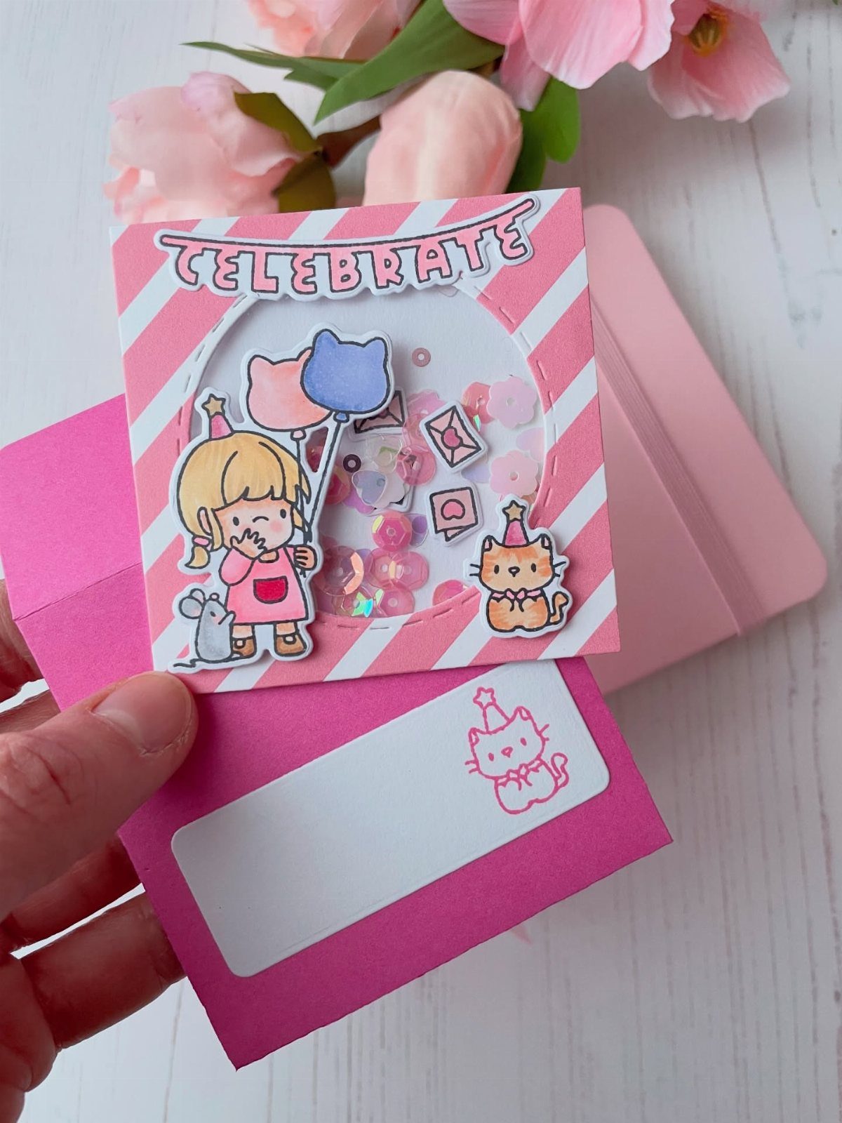 Pink striped birthday card with a confetti shaker window and cartoon characters.