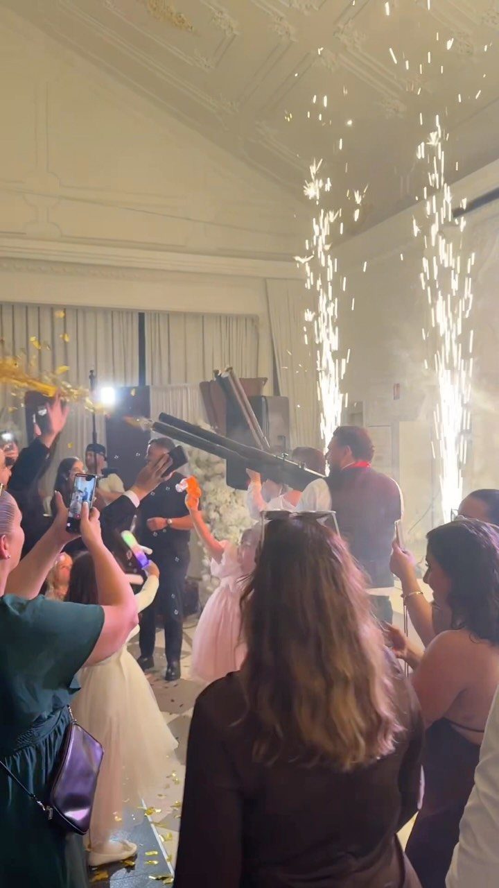 Indoor sparkler fountains emitting bright white sparks during a wedding dance floor celebration.