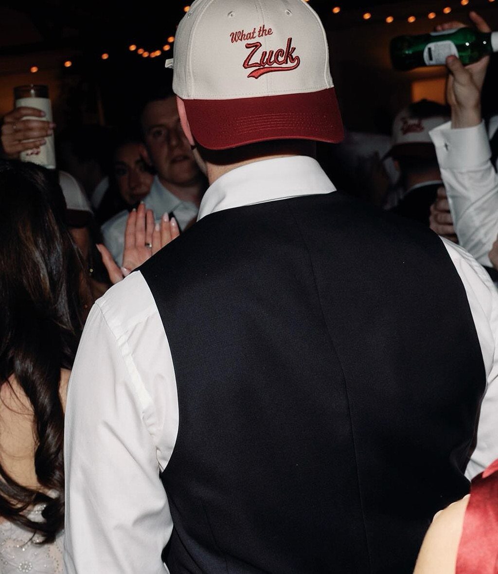 Man wearing a custom white and red baseball cap at a party event