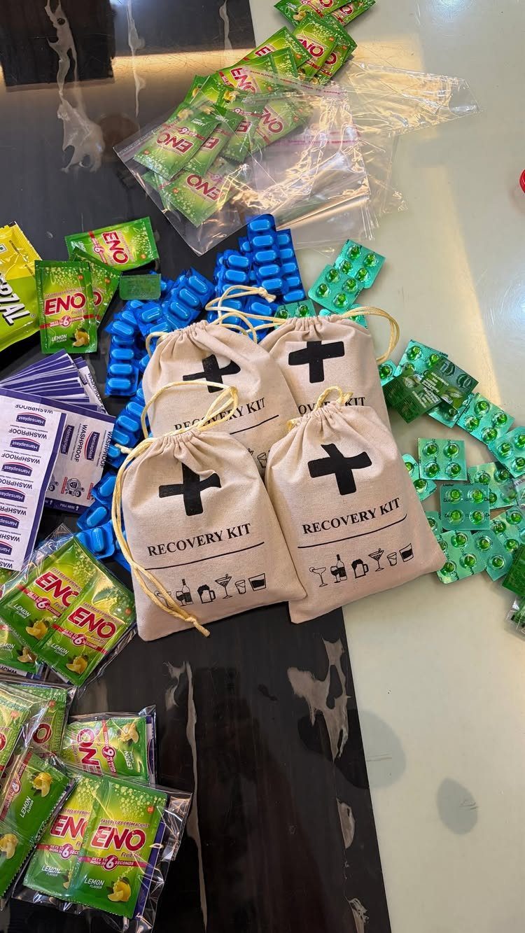 Beige drawstring recovery kit bags surrounded by medicine packets and blister packs.