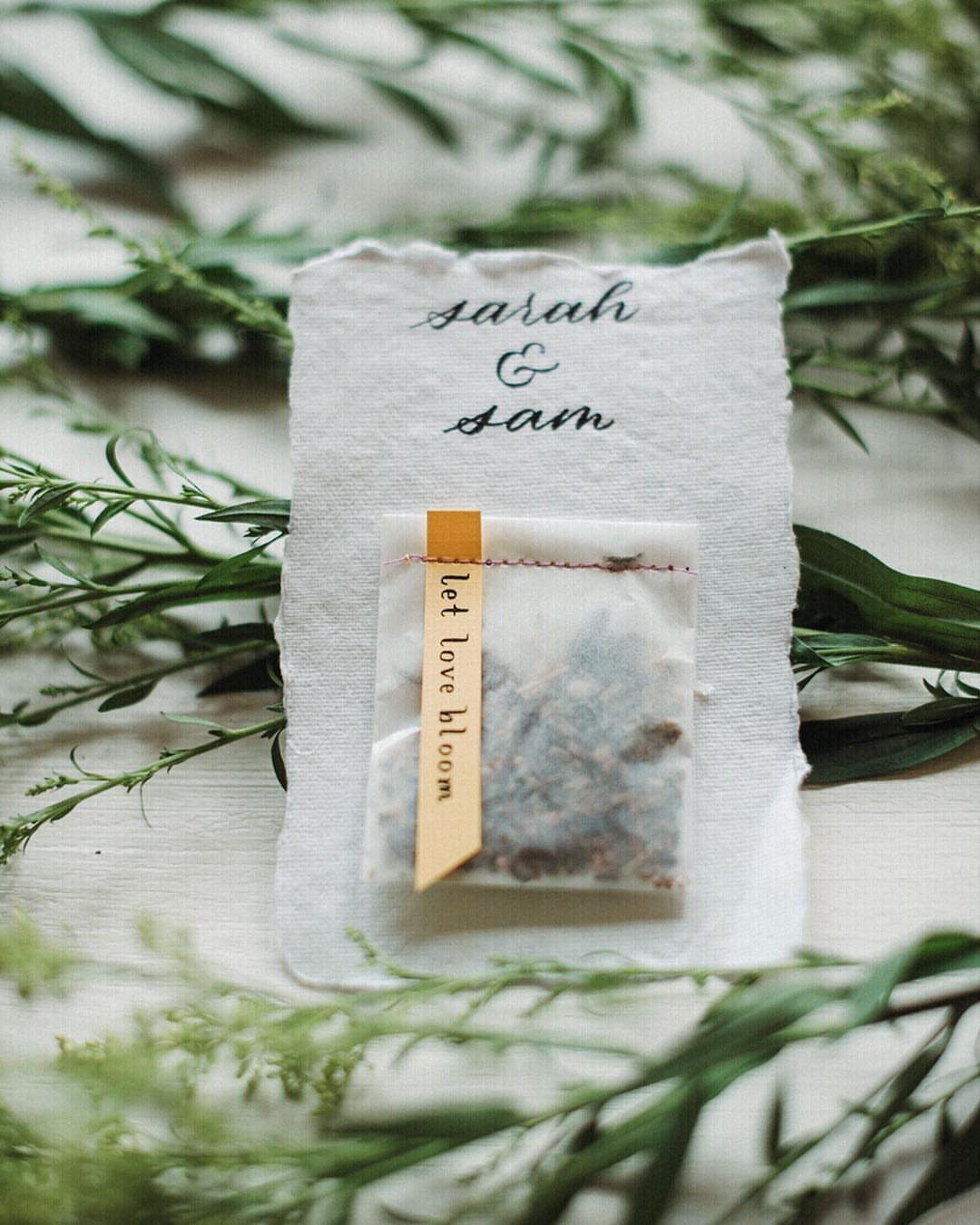 Seed packet with 'let love bloom' tag on a personalized wedding card.
