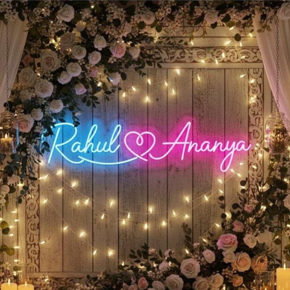 Neon sign with names Rahul and Ananya surrounded by roses and string lights.